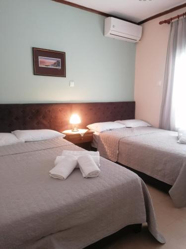 a hotel room with two beds with towels on them at Dimitris appartment in Stavros