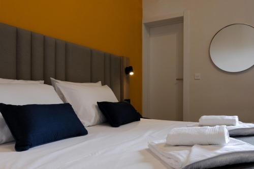 una camera da letto con un letto bianco e asciugamani di Mulberry Suites a La Valletta