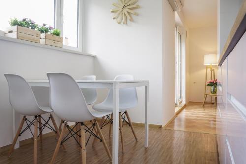 comedor con mesa y sillas blancas en Bright Apartment, en Liubliana