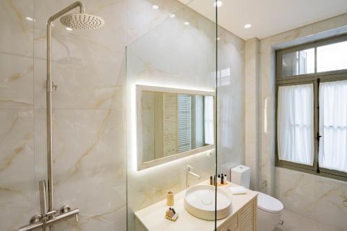 a bathroom with a shower and a sink and a toilet at Eramai in Patra