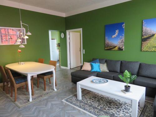 ein Wohnzimmer mit einem Sofa und einem Tisch in der Unterkunft Den lille Skole - Ferie på Ærø i Marstal by in Marstal