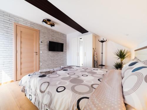 a bedroom with a large bed and a brick wall at Ben Apartments in Sibiu