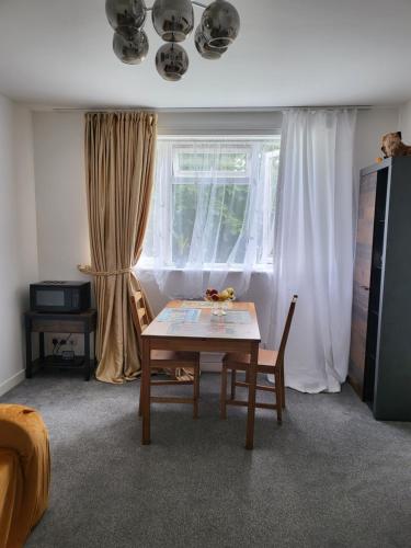 Una sala de estar con una mesa y sillas y una ventana. en Nice, en Torquay
