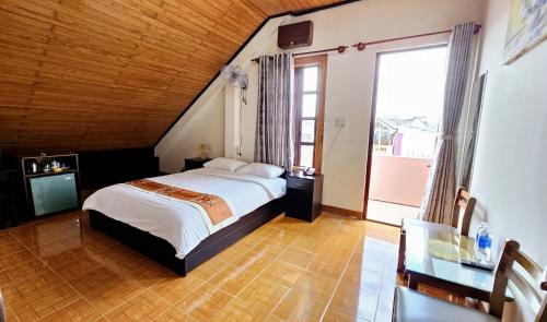 a bedroom with a bed and a large window at Villa Pink House in Da Lat