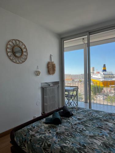 une chambre avec un lit et une grande fenêtre dans l'établissement Le marin, à Toulon