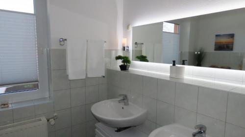 a white bathroom with a sink and a mirror at Ferienhaus Sava in Garz-Usedom