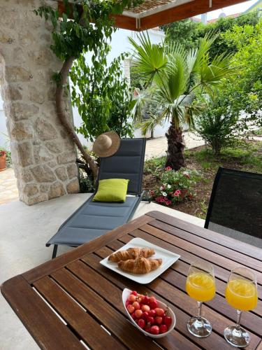 una mesa con un plato de comida y dos vasos de zumo de naranja en Apartments Xenia Pakoštane, en Pakoštane