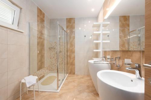 a bathroom with a shower and a sink and a tub at Villa Sveti Petar - with heated pool and outdoor jacuzzi in Opatija