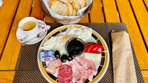 a plate of food on a table with a cup of coffee at Hotel Tata Si Fii in Bechet