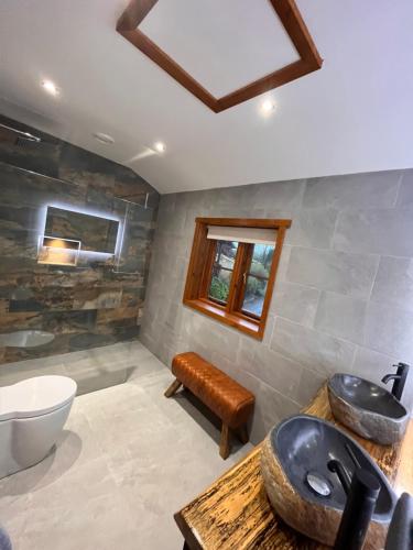 a bathroom with a sink and a toilet and a tub at Romantic Log Cabin With Hot Tub in Leominster