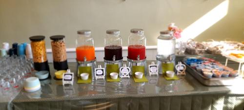 a table with many bottles of different colored liquids at Hotel Maddalena in Marina di Ravenna