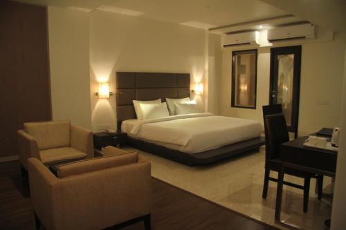 een hotelkamer met een bed, een bureau en stoelen bij Hotel Beacon T2 in Mumbai