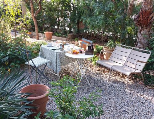 a table and two chairs in a garden at La villa des Amandiers in Hyères