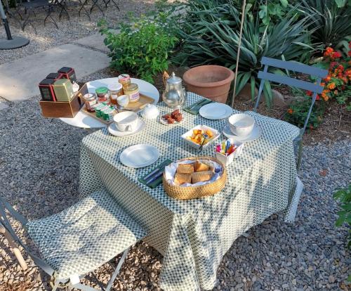 a picnic table with a basket of food on it at La villa des Amandiers in Hyères