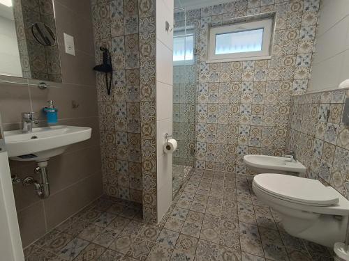 a bathroom with a toilet and a sink at Wegzen in Hévíz