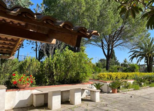 a bench in a park with flowers and plants at Villa Claudia - casa vacanze in Agropoli