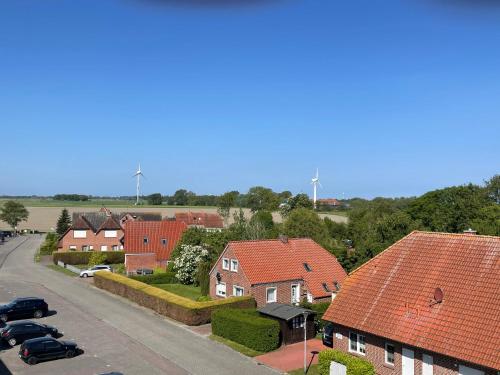 a residential neighborhood with red roofs and a street at Nordseeglück Franz in Dornumersiel