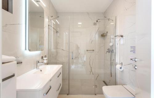 a white bathroom with a shower and a sink at Nice Apartment In Malinska With Heated Swimming Pool in Malinska