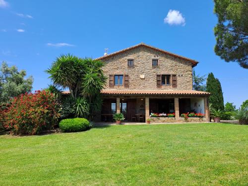 uma antiga casa de pedra com um grande quintal em Podere Belvedere Villa Classic Tuscan em Magliano in Toscana