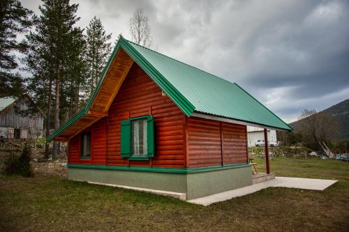 a small wooden house with a green roof at Apartman Djokovic in Žabljak