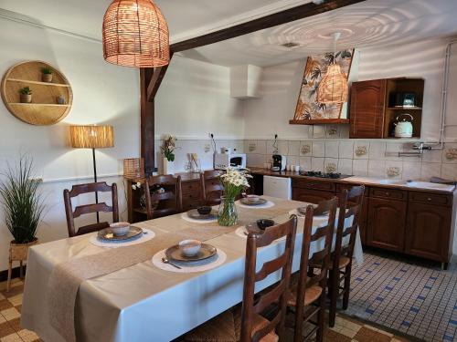 una cocina con mesa y algunas sillas y una cocina con en Le Clos Loret en Saint-Germain-du-Corbéis