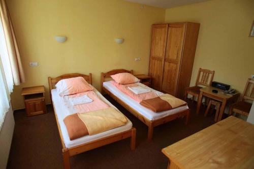 Habitación con 2 camas, mesa y sidx sidx sidx de mesa en Hotel Nad Mrogą, en Koluszki