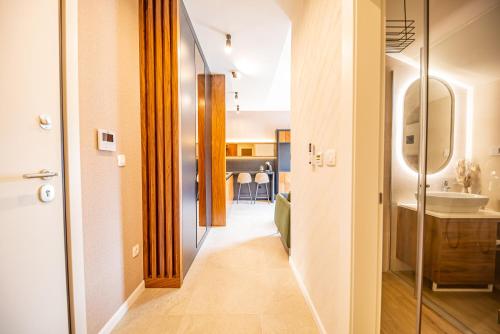 a hallway with a bathroom with a sink and a mirror at Enyana Luxury Suites in Kotor