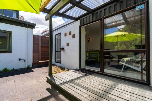 eine offene Terrasse mit einem Sonnenschirm und einem Tisch in der Unterkunft Elegant Townhouse in Taupo
