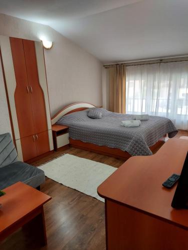 a small bedroom with a bed and a couch at Хотел Лагуна in Dospat
