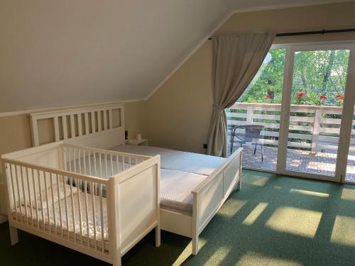 薩拉茨格里瓦的住宿－La Familia Seaside Residence，窗户房间里一张白色的婴儿床