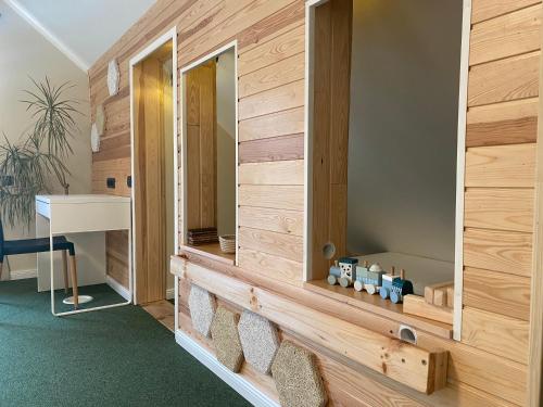 Cette chambre est dotée d'un mur en bois avec un miroir. dans l'établissement La Familia Seaside Residence, à Salacgrīva