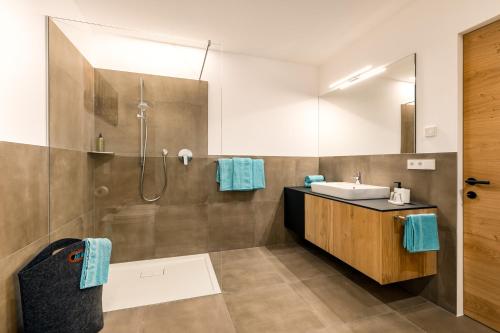 La salle de bains est pourvue d'un lavabo et d'une douche. dans l'établissement Apartments Baumann Living, à Rodengo