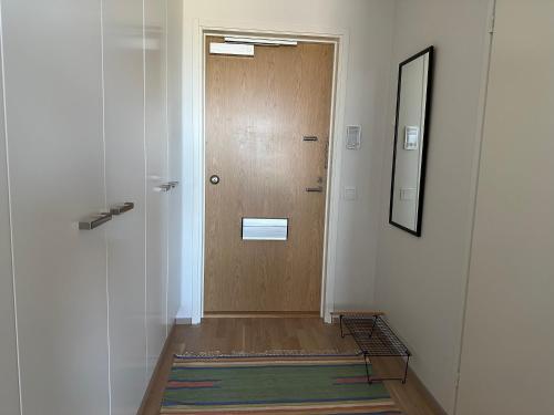 a hallway with a wooden door and a mirror at Near center w/ smart-TV, tram stop and gym visit in Tampere