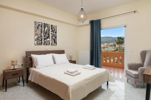 a bedroom with a bed and a couch and a window at Villa Androniki in Souda