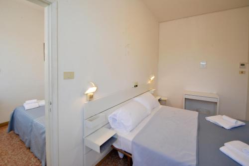 a small bedroom with a bed and a mirror at Hotel Maddalena in Marina di Ravenna