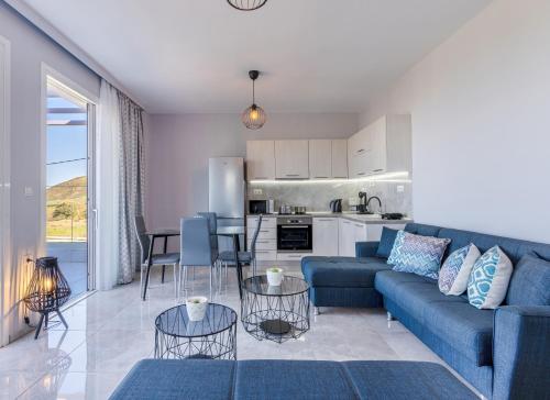 a living room with a blue couch and a kitchen at Sun Angelo luxury apartment in Paradise 1 in Arménoi