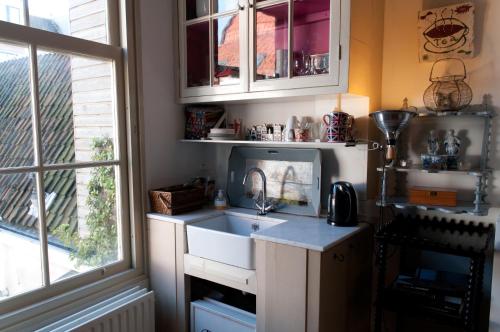 a kitchen with a sink and a window at B&B Herengracht 21 in Amsterdam