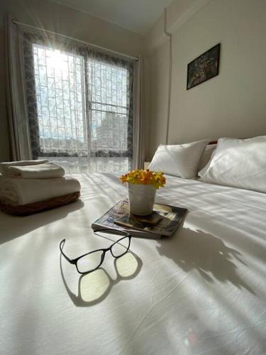 a pair of glasses sitting on top of a bed at 1 min walk to BTS, 3 Bed 3 Bath, Entire House in Bangkok
