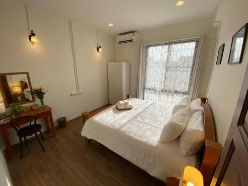 ein Schlafzimmer mit einem weißen Bett und einem Fenster in der Unterkunft 1 min walk to BTS, 3 Bed 3 Bath, Entire House in Bangkok