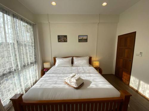 ein Schlafzimmer mit einem großen Bett mit weißer Bettwäsche in der Unterkunft 1 min walk to BTS, 3 Bed 3 Bath, Entire House in Bangkok