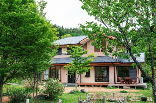 een huis met een zwart dak en enkele bomen bij LiveGRACE Villa Lake Kawaguchiko 富士河口湖 in Yamanashi