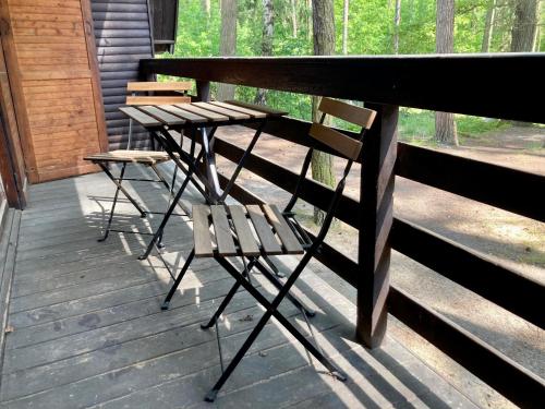 a picnic table and two chairs on a porch at Chatová osada Zelený Háj in Merklín