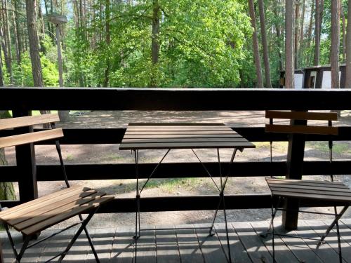 a picnic table and two benches on a porch at Chatová osada Zelený Háj in Merklín