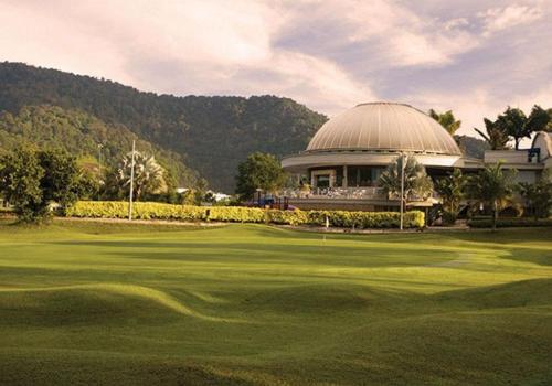 vistas a un campo de golf con un edificio en Casa Kayangan @ Meru 6 Pax Blissful Suite en Ipoh