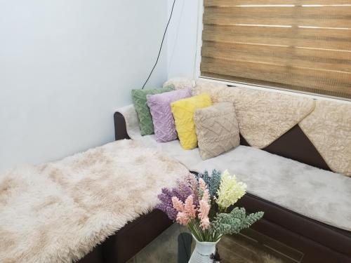 a couch with colorful pillows and a vase of flowers at Family Groups Staycation in Tagaytay in Tagaytay