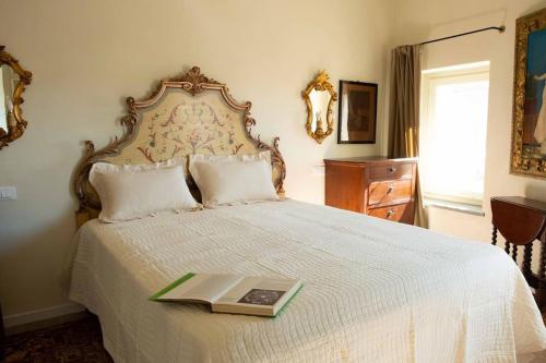 Un dormitorio con una cama con un libro. en Ai Leoni Ruggenti - Giardino Segreto con Vista sul Monferrato, en Ottiglio