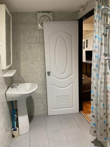 a bathroom with a white door and a sink at Zappa Guesthouse in Pattaya