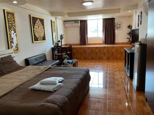 a bedroom with a large bed and a television at Zappa Guesthouse in Pattaya