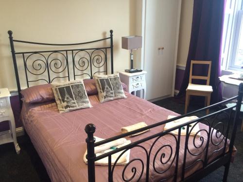 a bedroom with a black bed with pink sheets and pillows at Adam Drysdale House in Edinburgh