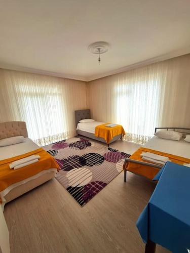 a room with two beds and a rug at My Home in Beysehir